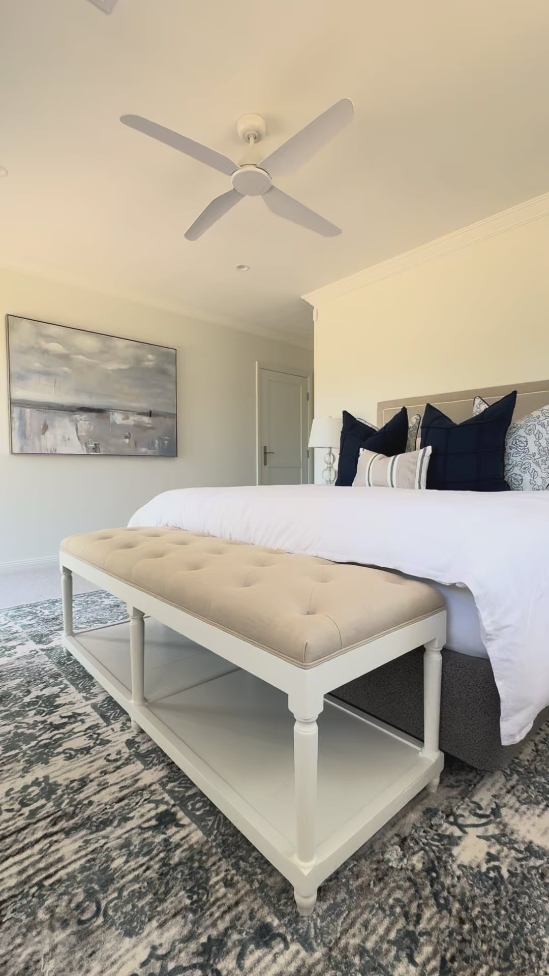 hamptons bench seat with natural linen chesterfield top with white timber base sitting at the end of the bed for storage in bedroom